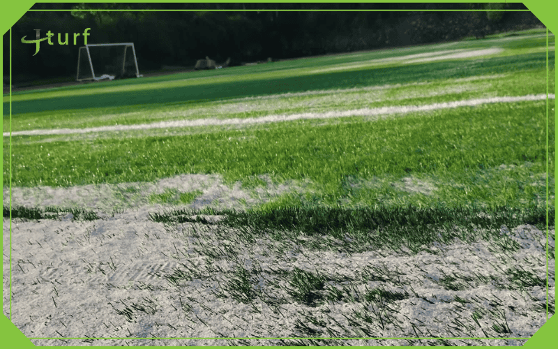 How Often Should You Add Sand to Artificial Grass? 2 Sports field with artificial grass showing exposed turf sand infill and wear zones