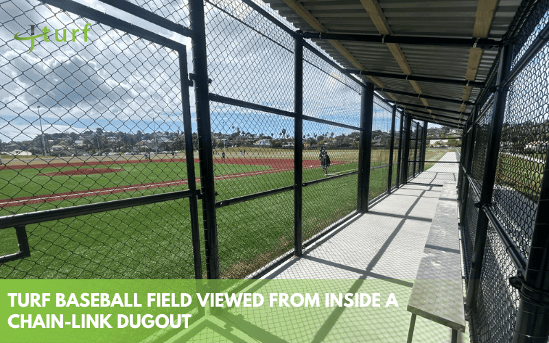 Una mirada clara al costo de construir un campo de béisbol de césped 3 Campo de béisbol de urf visto a través de una caseta de alambre con jugadores a la distancia